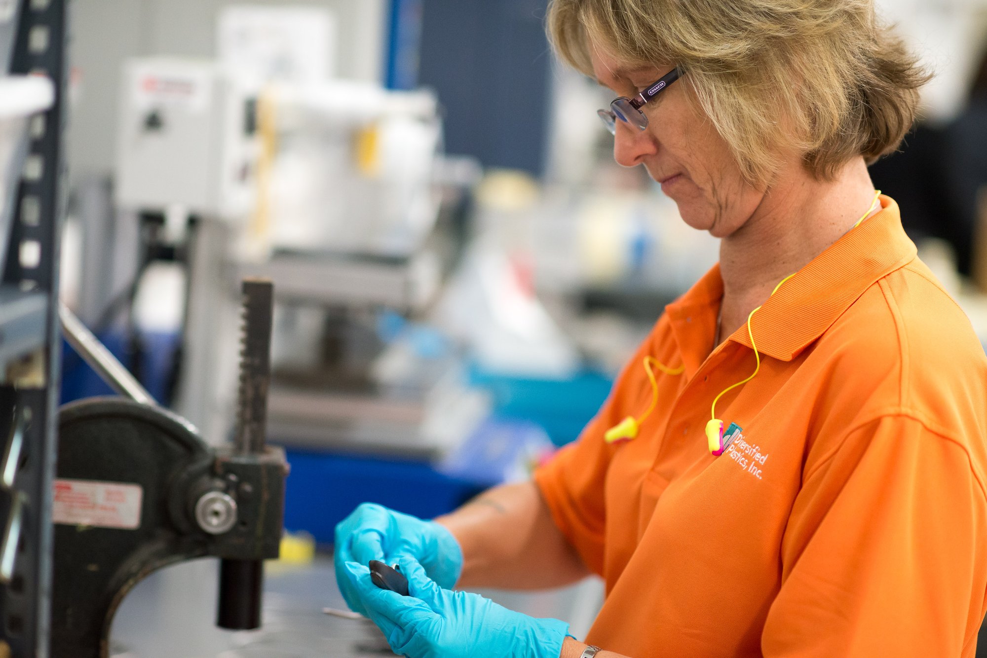 Aprios technician post processing an injection molded part.